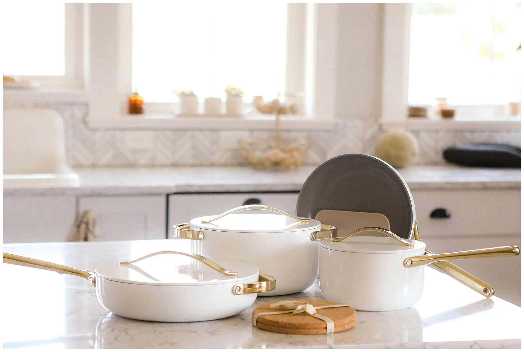 White pots and pans on kitchen countertop.